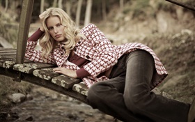 金发女孩躺在木桥上，外套