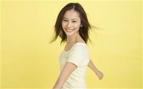 快乐的亚洲女孩，黄色的背景 高清壁纸
