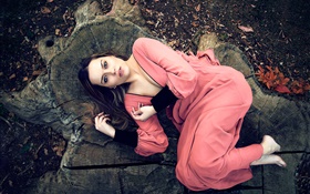 粉红色连衣裙的女孩躺在树桩上 高清壁纸
