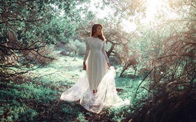 白色连衣裙的女孩在森林，阳光，眩光