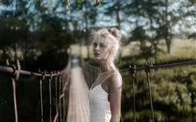 白色礼服的金发女孩在桥上